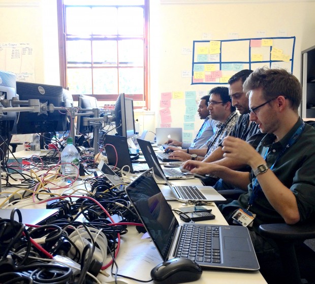 Cabinet Office Technology Transformation programme team sitting at crowded desks with lots of laptops and wires 