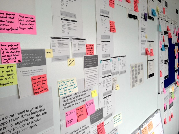 Example of a user research wall with print outs of the service and annotations on post its 