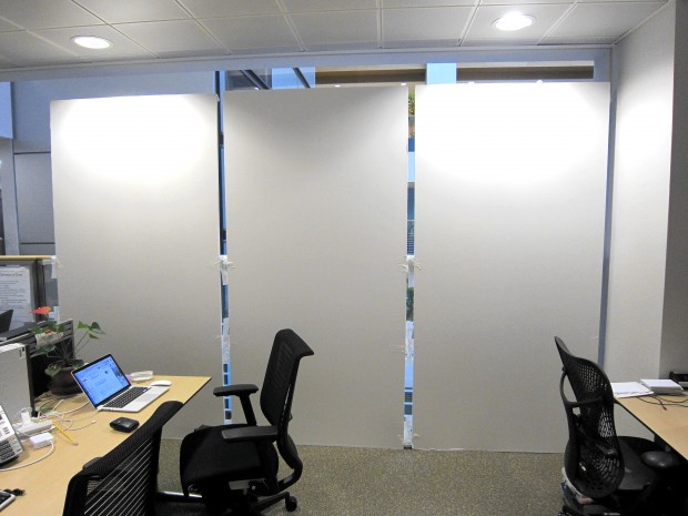 Blank research wall in an office, next to desks and chairs 