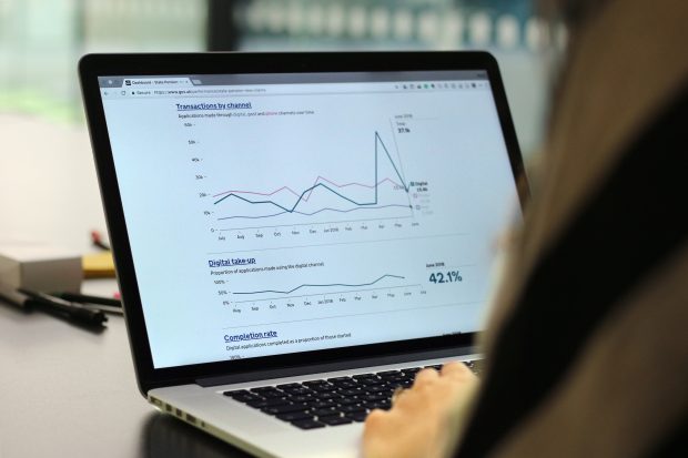 A laptop showing performance data graphs for a GOV.UK service