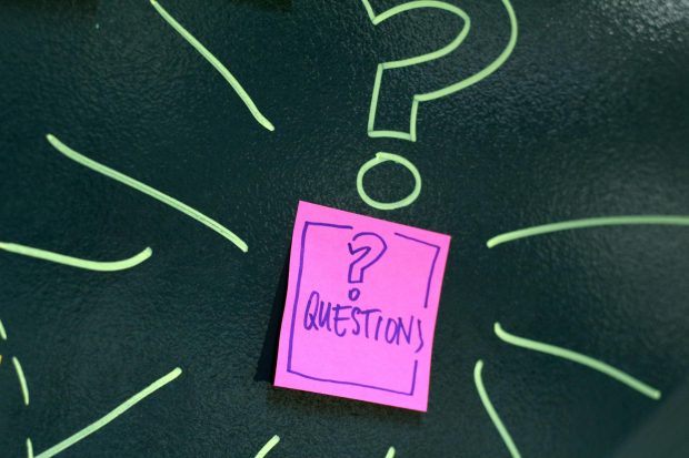 A blackboard with a green question mark drawn on it. There is also a Post It note stuck below, with a question mark drawn on it and the word 'questions'