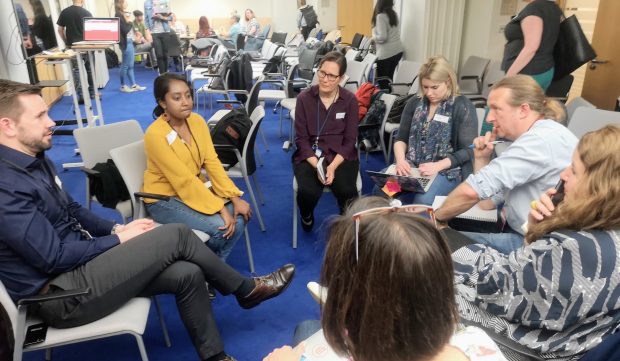 A group of people sitting in a circle having a discussion during the research ethics meetup